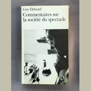 Couverture du livre Commentaires sur la société du spectacle de Guy Debord en noir et blanc avec l’auteur observant un jeu de stratégie
