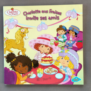 Couverture jaune de l’album « Charlotte aux Fraises invite ses amis » : Charlotte au grand chapeau rose décore un gâteau entourée de ses amies et d’un poney, style dessin animé Tiji.