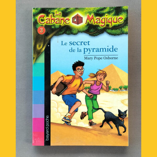 Couverture de La Cabane magique – tome 3 : Le secret de la pyramide — Tom, Léa et un chat noir courant devant des pyramides, logo collection « La Cabane magique ».