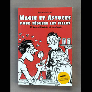 Couverture rouge du livre « Magie et Astuces pour séduire les filles » : dessin humoristique en noir et blanc (scène au restaurant), pastille jaune « Inclus un accessoire à découper », titre blanc en grosses lettres.