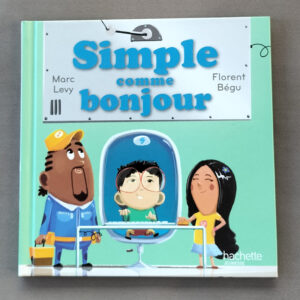 Couverture vert d’eau de l’album « Simple comme bonjour » : enfants autour d’une grande machine, un personnage assis derrière une vitre, typographie bleue, logo Hachette Jeunesse.