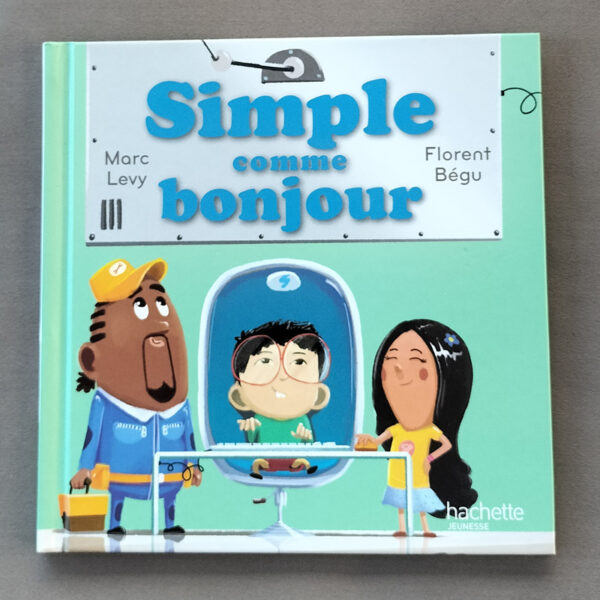 Couverture vert d’eau de l’album « Simple comme bonjour » : enfants autour d’une grande machine, un personnage assis derrière une vitre, typographie bleue, logo Hachette Jeunesse.